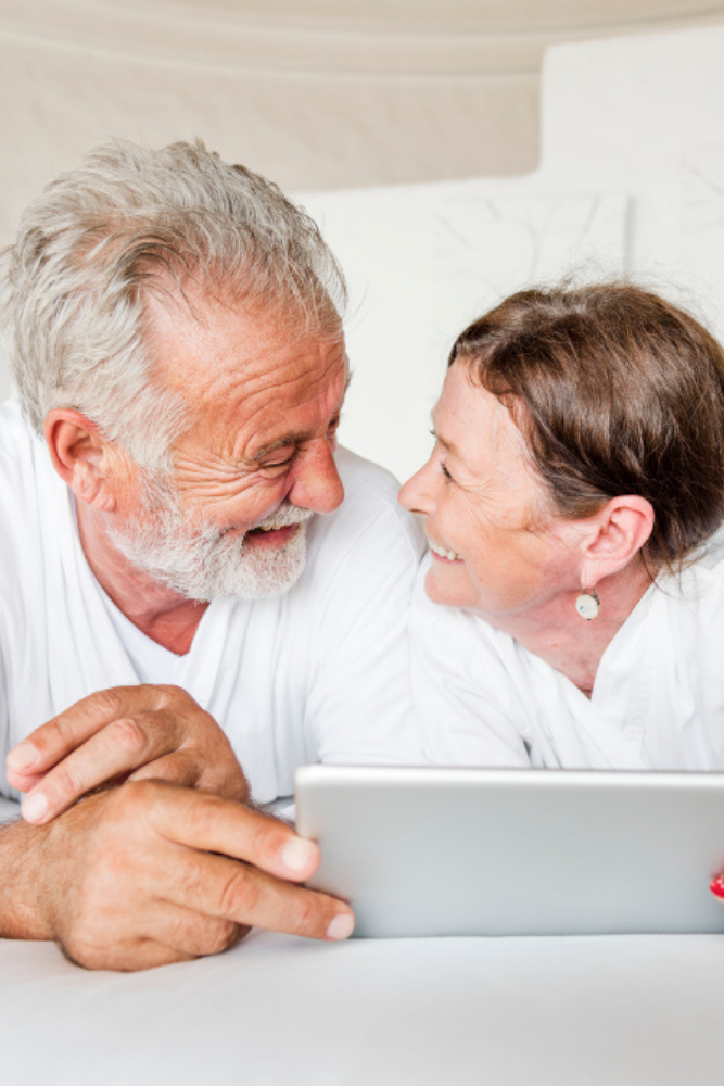 Carousel Photo 5 Senior Couple Watching Ipad On Bed | Heritage Waterside Senior Couple Watching Ipad On Bed