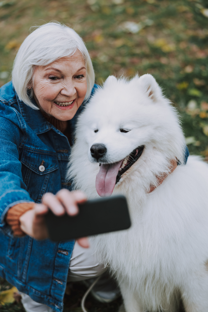 Volunteer Grandma Taking A Selfie With A Dog | Heritage Waterside Financial Planning For Seniors | Bahama Bay Club